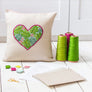 Botanical heart cross stitch cushion with threads, pattern and fabric.