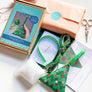 Contents of kit to make cross stitch Christmas tree decoration including pattern aida, threads, stuffing, green felt and green ribbon.