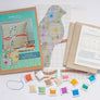 Materials included in the cross stitch kit including thread, pattern, fabric, instructions and outer packaging