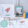 Framed cross stitched rocket with packaging threads and pattern