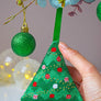 Person hanging cross stitch Christmas tree decoration