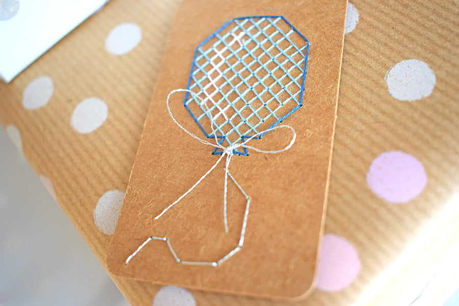 Close up of cross stitch gift tag featuring balloon.