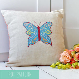 Cross stitch butterfly pattern made into a cushion with flowers.