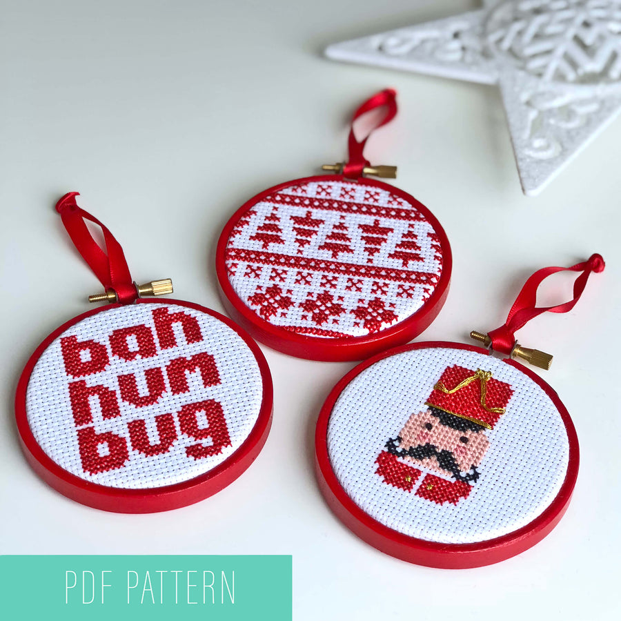 Trio of cross stitched Christmas design baubles in red three inch embroidery hoops