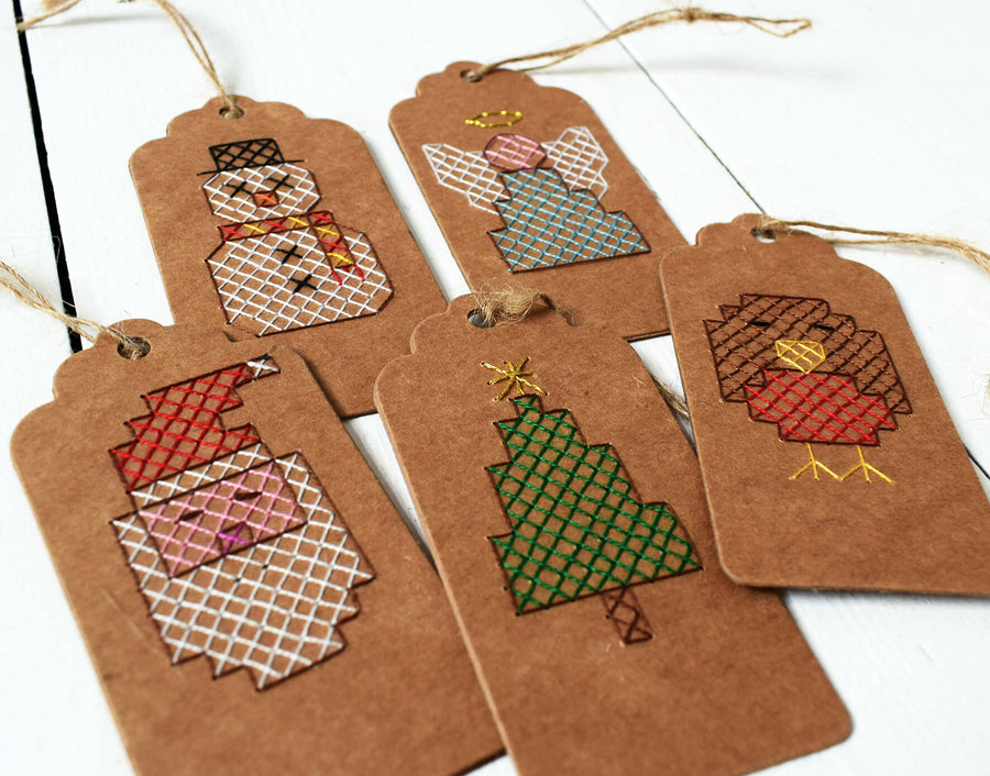 Five designs of stitched tags shown together on an angle