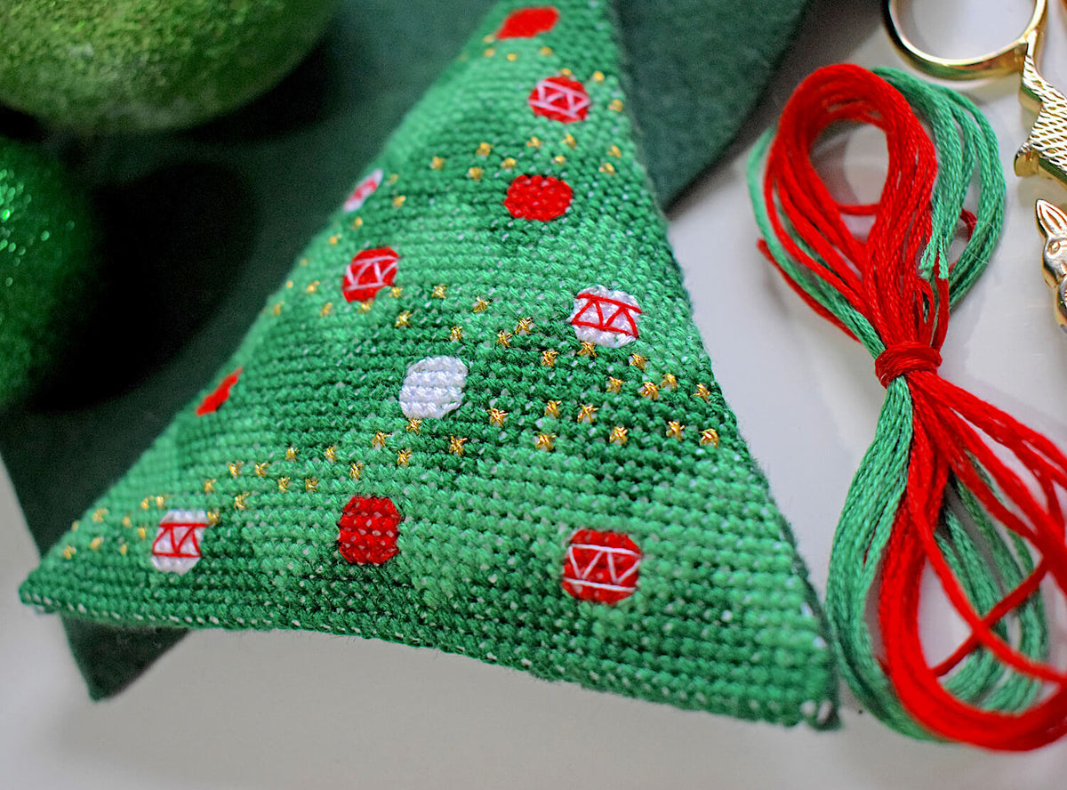 Christmas tree shaped cross stitch decoration with threads
