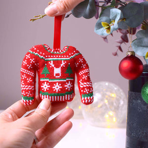 Cross stitch Christmas jumper Christmas decoration being hung on a branch