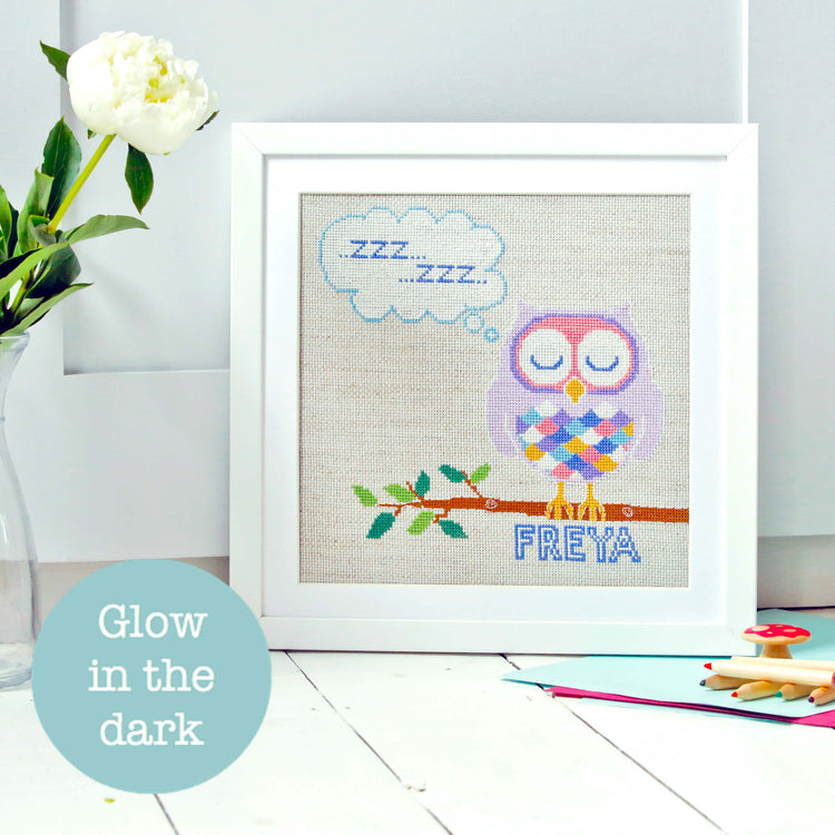 Framed cross stitch pattern of purple owl on branch with sleeping thought bubble.