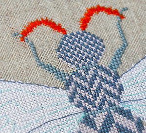Close up of herringbone design cross stitches within the insect upper body and wings
