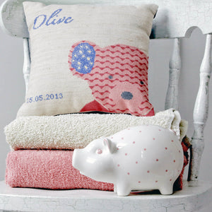 Pink teddy cross stitch design made into a cushion with a piggy bank and towels