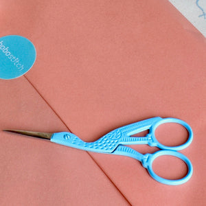 pale blue stork scissors on gift wrapped box