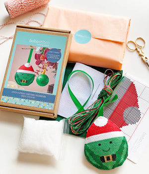 Cross stitch kit contents to create Christmas sprout including packaging, aida, felt, ribbon, thread and stuffing