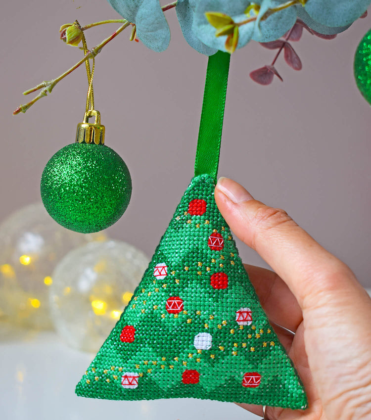 Person hanging cross stitch Christmas tree decoration