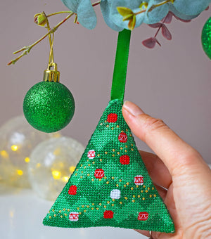 Person hanging cross stitch Christmas tree decoration